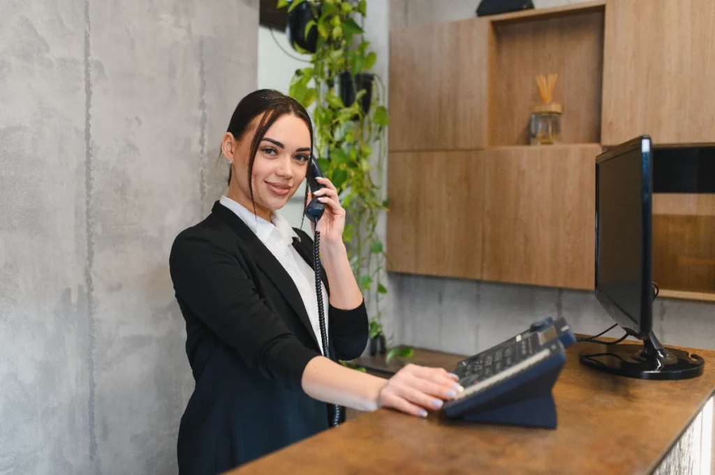 An office receptionist handling a call, providing a service included in serviced offices