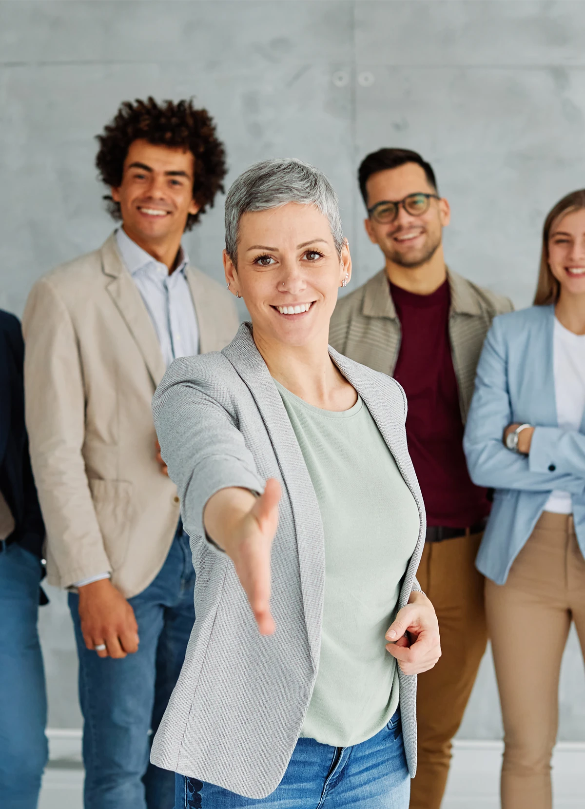 Group of premium business clients, one of them reaching for a handshake