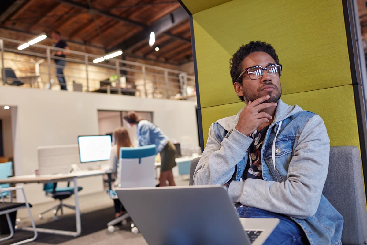Man works in a coworking space, deep in thought